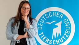 Portrait von Nadine Neuhaus vor dem Logo des Deutschen Tierschutzbundes