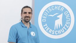 Portrait von David Knitter vor dem Logo des Deutschen Tierschutzbundes