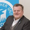 Tierschutzbund-Präsident Thomas Schröder sitzt vor dem Logo des Deutschen Tierschutzbundes
