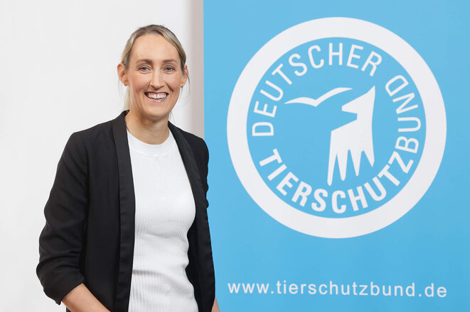 Portrait von Judith Schoenstein vor dem Logo des Deutschen Tierschutzbundes