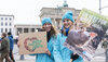 Zwei junge Frauen mit Demo-Plakaten zur Demo "Wir haben es satt" vor dem Brandenburger Tor in Berlin